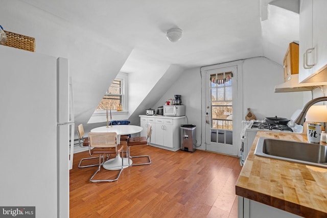 office area featuring light wood-type flooring, a sink, and lofted ceiling