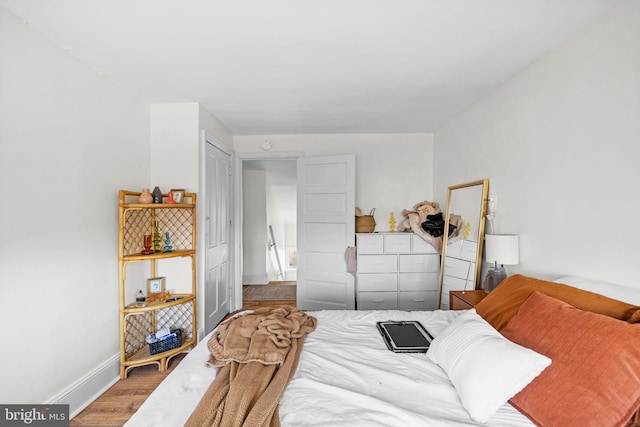 bedroom with baseboards and wood finished floors