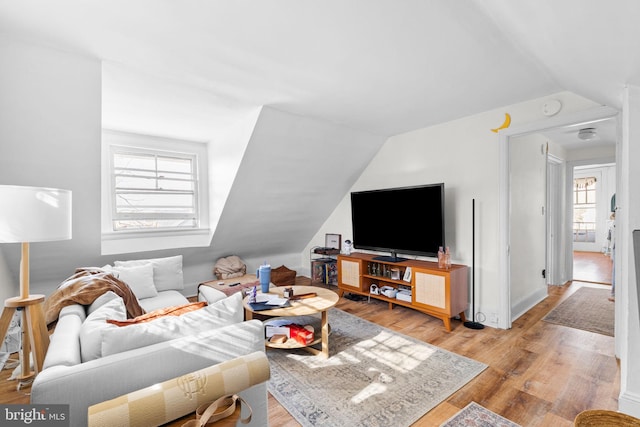 living room with light wood-style floors and lofted ceiling