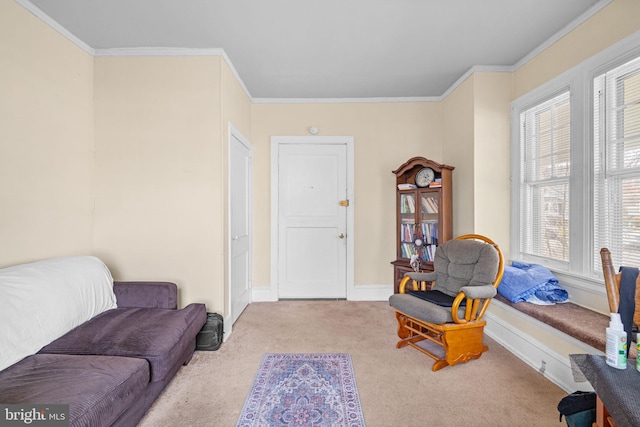 sitting room featuring baseboards, ornamental molding, and carpet flooring