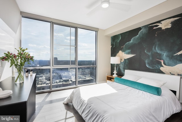 bedroom with floor to ceiling windows, a ceiling fan, and wood finished floors