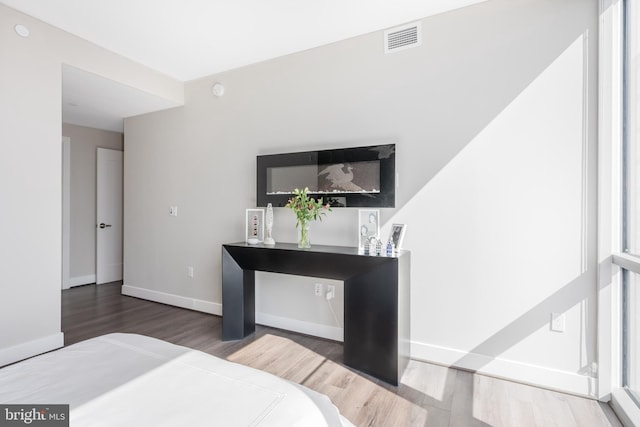 bedroom featuring visible vents, baseboards, and wood finished floors