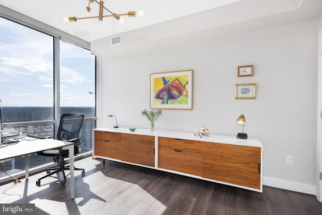 office featuring dark wood finished floors, visible vents, an inviting chandelier, a wall of windows, and baseboards