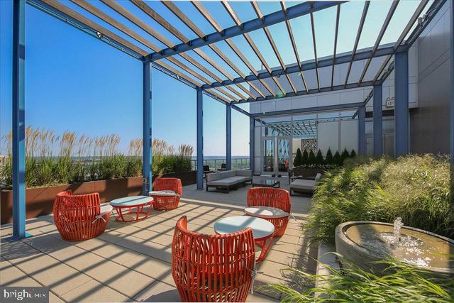 view of patio with an outdoor living space with a fire pit and a pergola