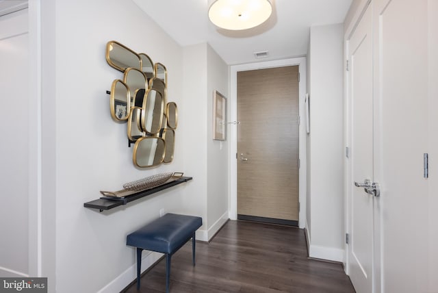 doorway to outside featuring visible vents, baseboards, and dark wood finished floors