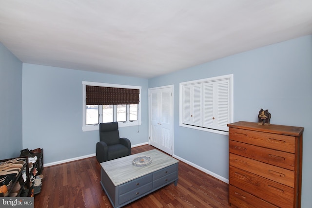 living area featuring dark wood-type flooring and baseboards