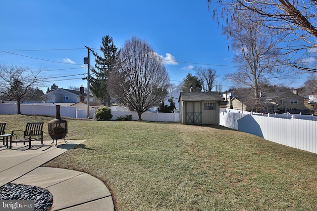 view of yard with a fenced backyard, a storage unit, a patio, and an outbuilding