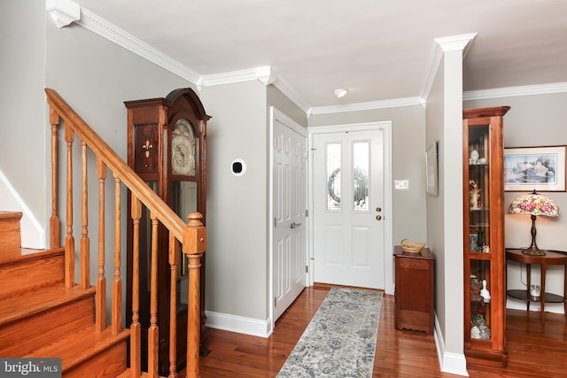 foyer entrance featuring ornamental molding, dark wood finished floors, stairway, and baseboards