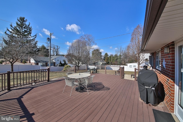 deck featuring an outdoor structure, a grill, and fence