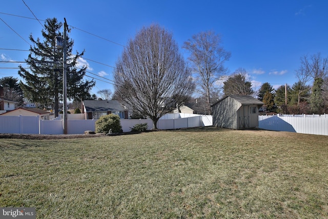 view of yard featuring a fenced backyard, a storage unit, and an outdoor structure