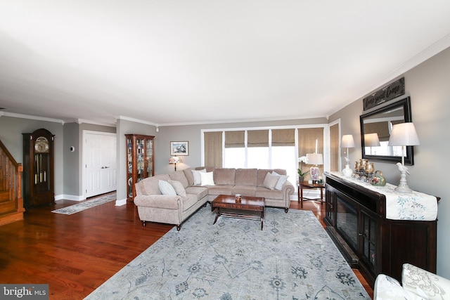 living area with a fireplace, crown molding, stairway, wood finished floors, and baseboards