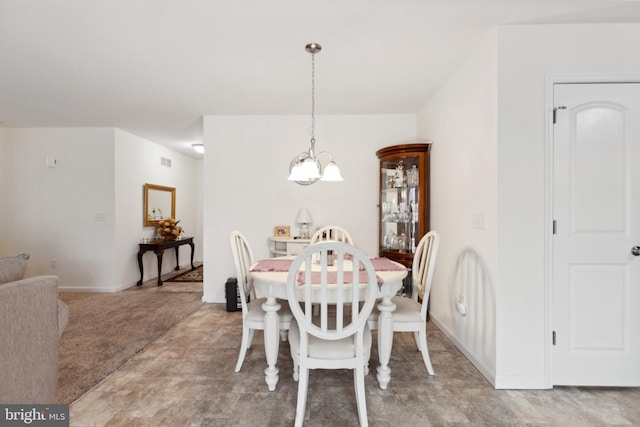 dining room featuring baseboards, visible vents, and a notable chandelier