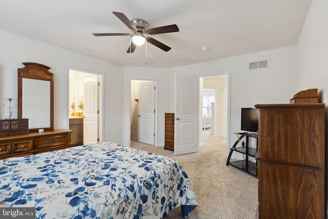 bedroom featuring light carpet, connected bathroom, visible vents, and a ceiling fan