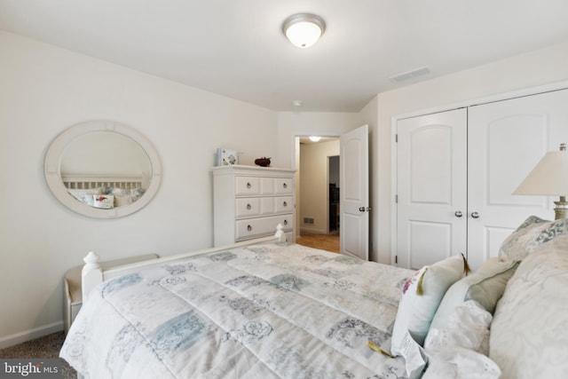 carpeted bedroom featuring baseboards, visible vents, and a closet