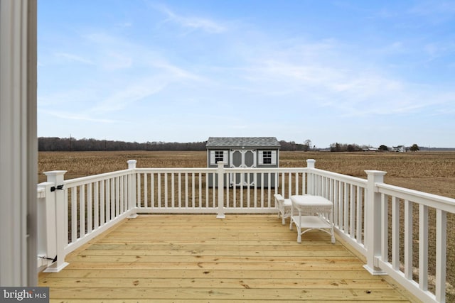 deck featuring an outbuilding, a rural view, and a storage shed