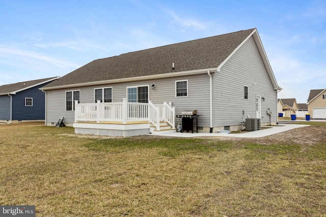 rear view of property with a shingled roof, a lawn, a deck, and central AC