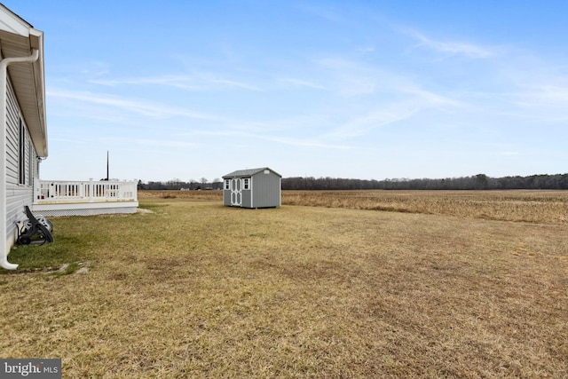 view of yard with a rural view, a storage unit, and an outdoor structure