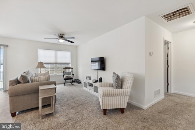 carpeted living area with a ceiling fan, visible vents, and baseboards