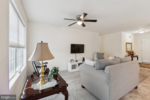 carpeted living room with a ceiling fan and baseboards