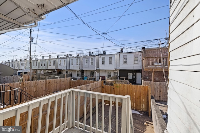 wooden terrace featuring a residential view and fence