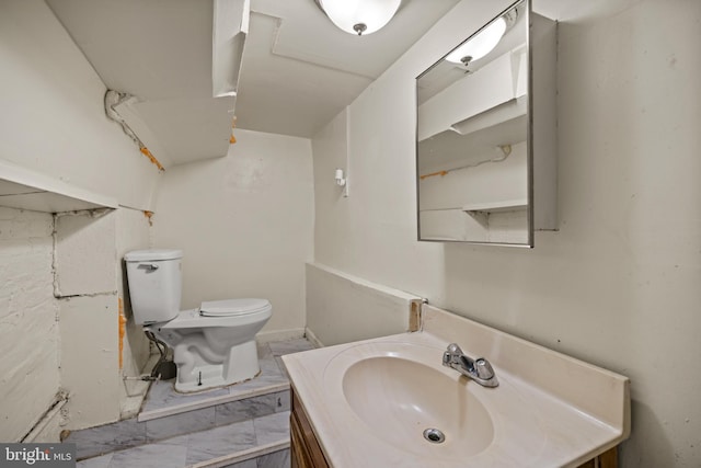 bathroom featuring toilet, marble finish floor, and vanity