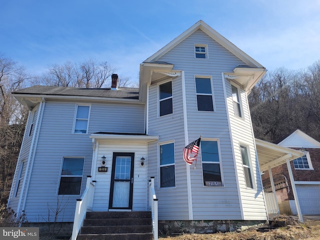 traditional-style house featuring entry steps and a chimney