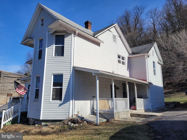 view of front of home featuring a porch and a chimney