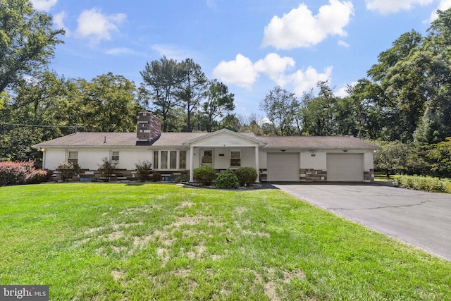 ranch-style home with a front yard, a garage, driveway, and a chimney