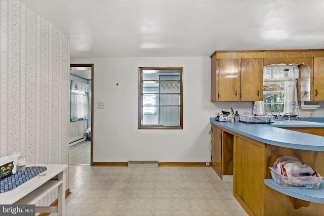 kitchen with visible vents, a sink, light floors, brown cabinetry, and a baseboard radiator