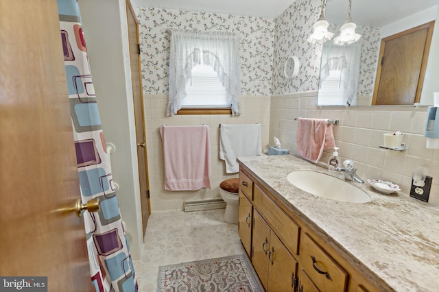 bathroom featuring a wealth of natural light, a wainscoted wall, wallpapered walls, and tile walls