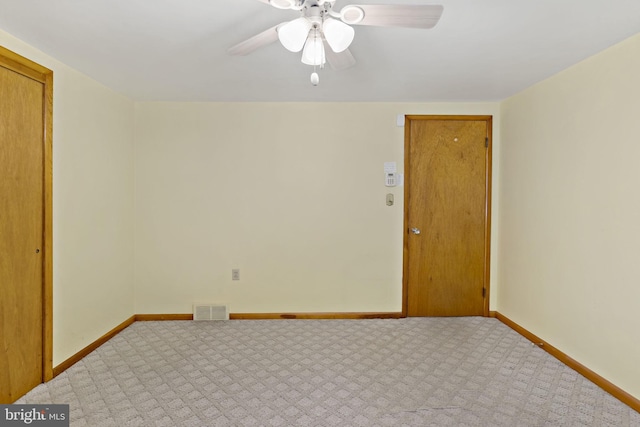 empty room with carpet flooring, baseboards, visible vents, and ceiling fan