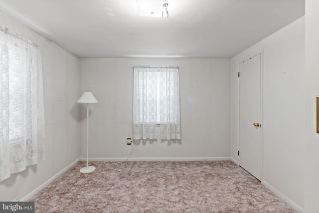 spare room with baseboards and carpet flooring