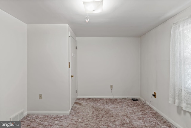 spare room featuring visible vents, carpet flooring, and baseboards