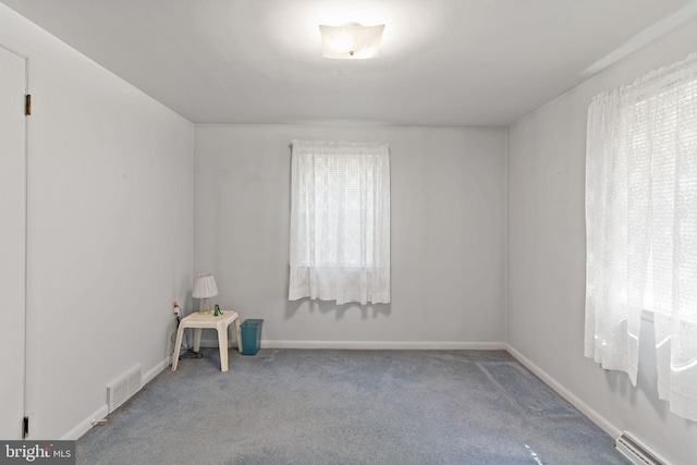 carpeted empty room with visible vents and baseboards