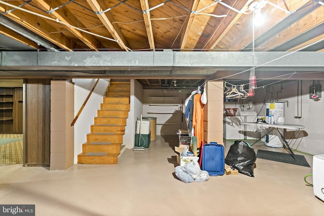 unfinished basement featuring stairs, washer / clothes dryer, and water heater