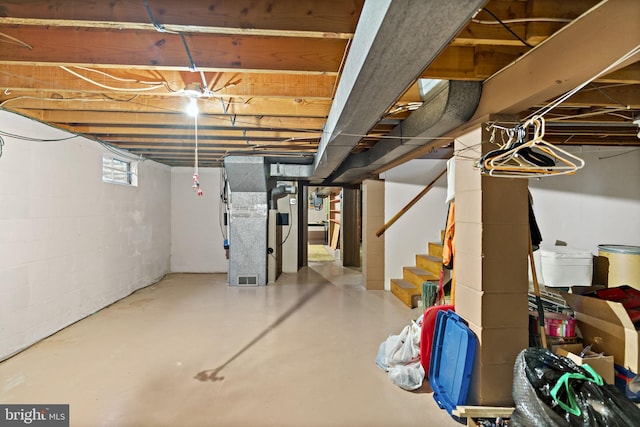 basement featuring stairway and heating unit