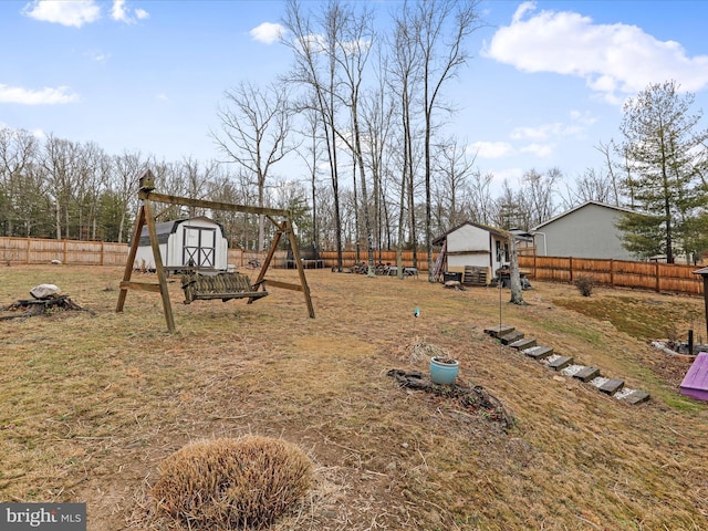 view of yard with an outbuilding, a fenced backyard, and a shed