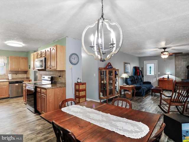 dining space with a textured ceiling, ceiling fan with notable chandelier, and light wood-style flooring