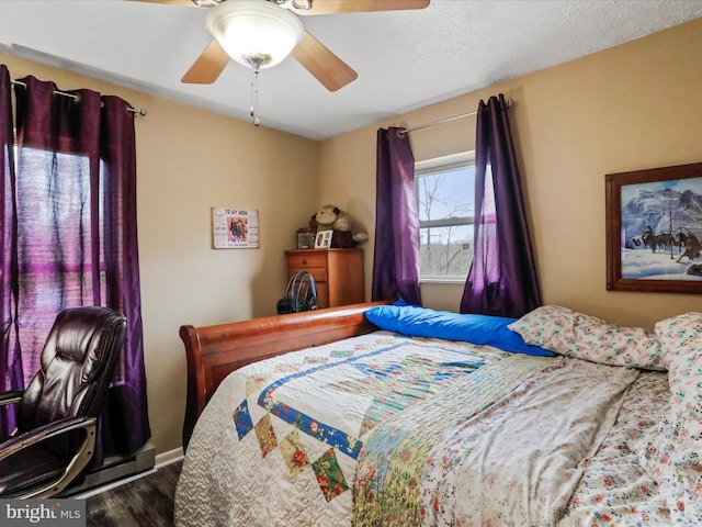 bedroom featuring dark wood finished floors, a textured ceiling, and ceiling fan