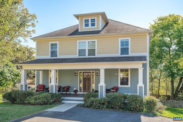 view of front of house with a shingled roof and a porch