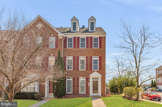 view of front of house featuring brick siding and a front lawn