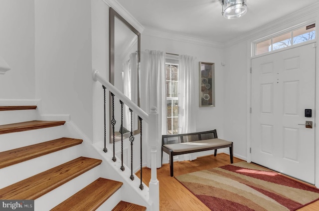 entryway featuring crown molding, stairway, and wood finished floors