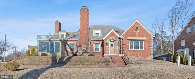 tudor home featuring brick siding and a chimney