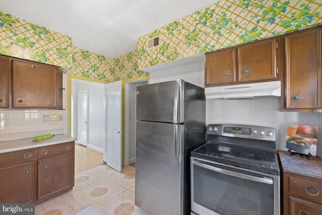 7310 Alaska Ave NW, Washington, DC 20012 - kitchen with visible vents, backsplash, appliances with stainless steel finishes, under cabinet range hood, and wallpapered walls