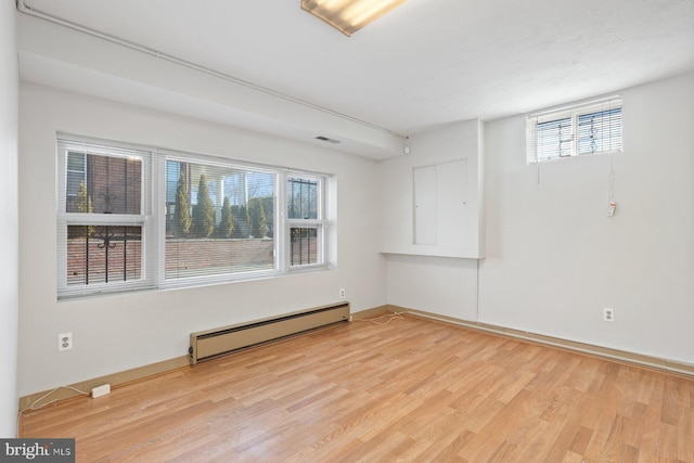 7310 Alaska Ave NW, Washington, DC 20012 - unfurnished room featuring a baseboard heating unit, light wood-type flooring, visible vents, and baseboards