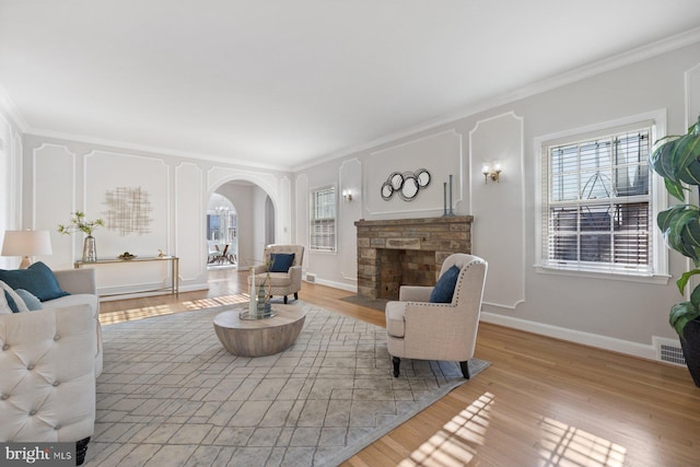 7310 Alaska Ave NW, Washington, DC 20012 - living room featuring light wood-style floors, arched walkways, visible vents, and a stone fireplace