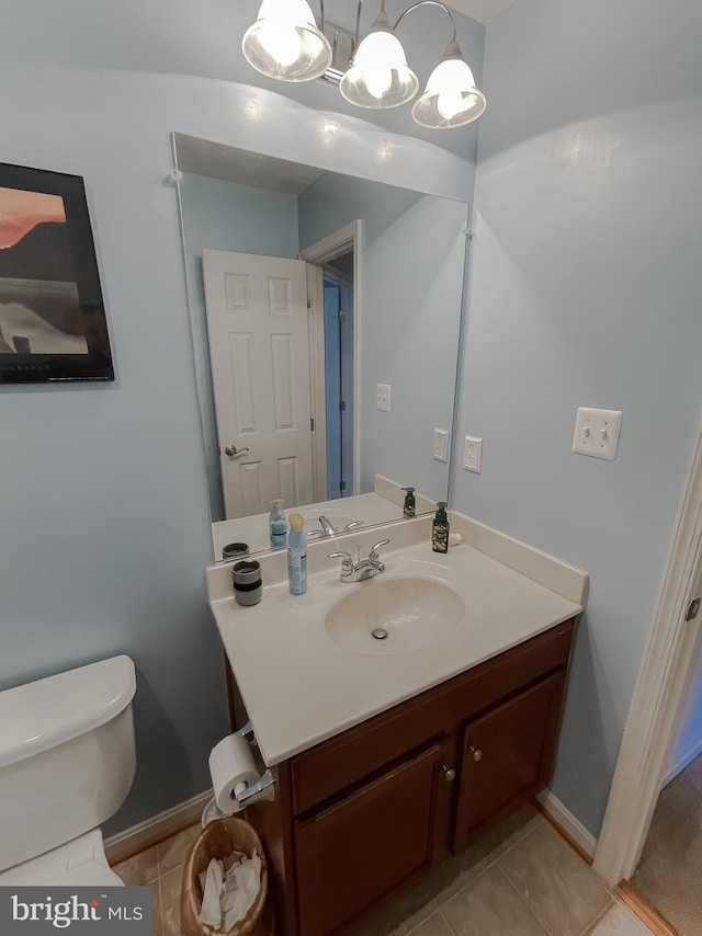 bathroom featuring tile patterned flooring, vanity, toilet, and baseboards