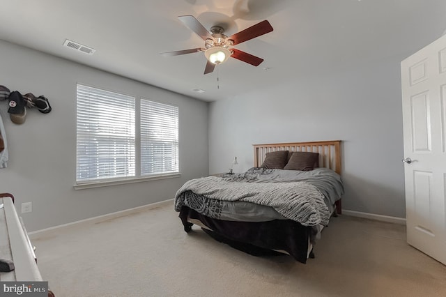 bedroom featuring baseboards, ceiling fan, visible vents, and light colored carpet