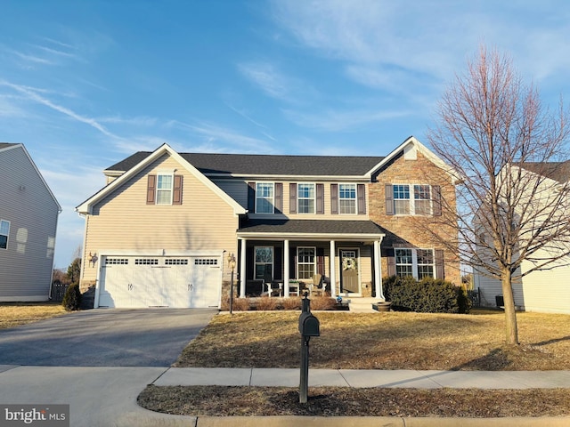 view of front of property featuring a porch, a garage, and driveway