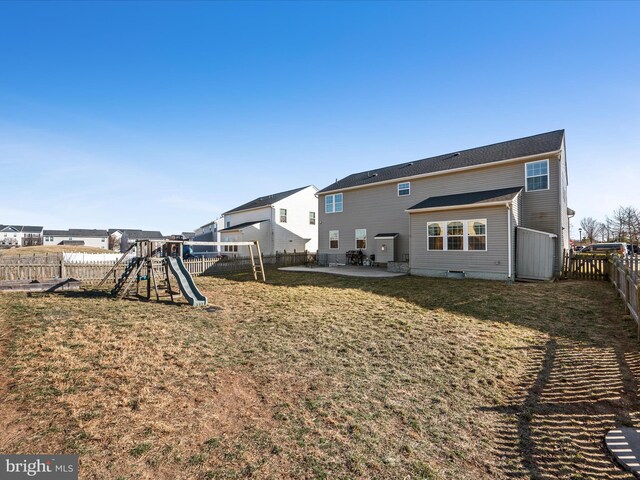 rear view of house featuring a patio and a playground